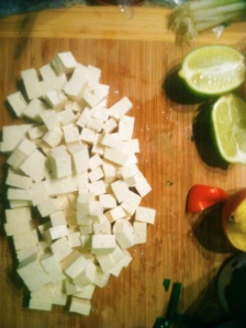 Tofu on the cutting board, cubed. 