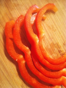 Slices of Red Bell Pepper on the Cutting Board, ready to be minced.